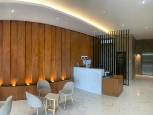 a lobby with white chairs and a reception desk at Kingsway Iligan Hotel in Iligan
