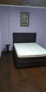 a bed in a room with a picture on the wall at Cabana Aconchegante in São Francisco de Paula +15 photos