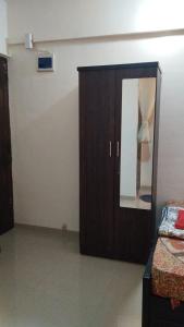 a bedroom with a wooden cabinet and a mirror at Decent furnished 1RK Navi Mumbai in Taloje +2 photos