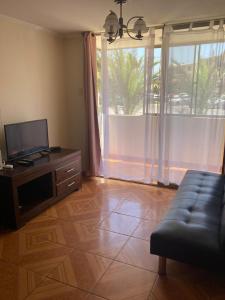 a living room with a couch and a large window at D11-4 Depto diario Arica in Arica