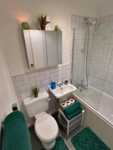 a bathroom with a toilet and a sink and a tub at Stunning 2BR Apt - City Centre - Sleeps 6 - Parking - 5g WiFi in Midland
