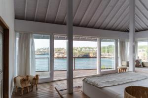 a bedroom with a large bed and large windows at Villa Tranquilla in Nusa Lembongan +30 photos