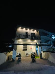 two motorcycles parked in front of a building at night at SM Suites in Kakkanad