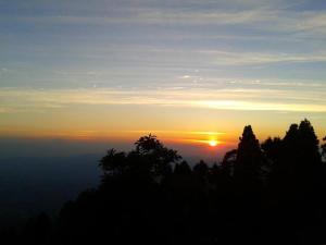 a view of the sunset from the top of a mountain at Cabaña Rústica Elena in Poás