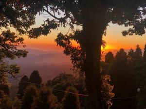 a sunset in the mountains with a tree at Cabaña Rústica Elena in Poás