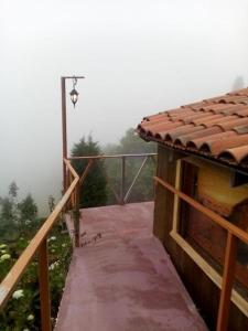 a walkway leading to a building with a foggy view at Cabaña Rústica Elena in Poás +1 photo