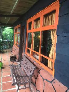 a bench sitting on the porch of a house at Cabaña Rústica Elena in Poás