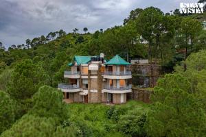an aerial view of a house on a hill at StayVista at Gulmohar Estate - 5BR Luxury House in Kasauli with Bonfire, BBQ & Lawn in Kasauli