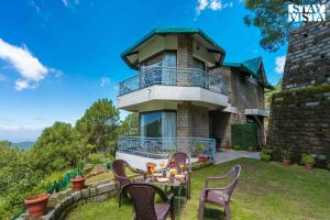 a house with a table and chairs in the yard at StayVista at Gulmohar Estate - 5BR Luxury villa in Kasauli in Kasauli