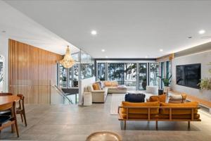 una sala de estar con un sofá y una mesa en Mimosa Lodge - 250m to Chinamans Beach in Jervis Bay!, en Hyams Beach