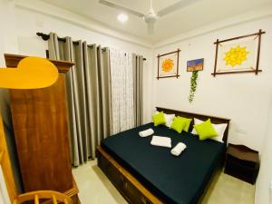 Un dormitorio con una cama con almohadas verdes. en New White Villa Ahangama, en Ahangama