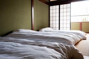 a bedroom with two unmade beds in front of a window at The83C in Takaoka