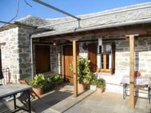 un patio con postes de madera y macetas en Sarafis Guesthouse, en Agios Lavredios