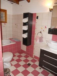 Baño de color rosa con aseo y lavamanos en Sarafis Guesthouse, en Agios Lavredios