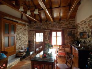 a living room with a table and a stone wall at Sarafis Guesthouse in Agios Lavrentios