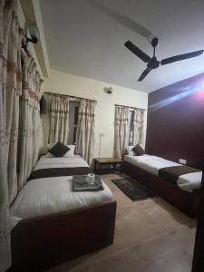 a bedroom with two beds and a ceiling fan at Hotel Blue lake in Pokhara