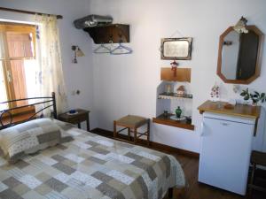 a bedroom with a bed and a mirror at Sarafis Guesthouse in Agios Lavrentios
