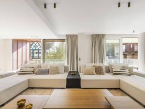 un soggiorno con un grande divano e finestre di Appartement de prestige 5 chambres au centre-ville avec WiFi et parking - FR-1-821-9 a Le Touquet-Paris-Plage