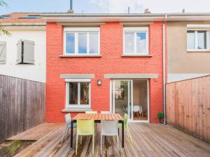 a house with a wooden table and chairs on a wooden deck at Charmante maison 3 chambres Quentovic, WiFi - FR-1-821-11 in Le Touquet-Paris-Plage