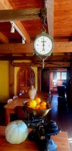 a clock and a bowl of fruit on a table at Streamside Country Manor- Matamata in Matamata