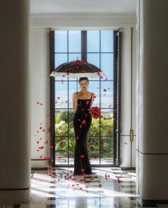 a woman in a black dress holding an umbrella at Dali Shuanglang Erhai Lake in Dali Shuanglang