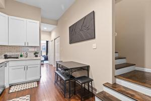 a kitchen with white cabinets and a table and chairs at Soulard Suite in Saint Louis +38 photos