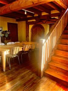 a dining room with a table and chairs and stairs at Streamside Country Manor- Matamata in Matamata