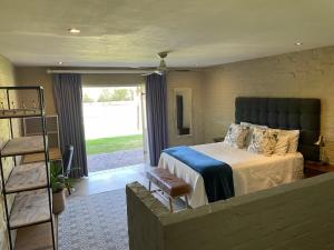 Un dormitorio con una cama grande y una escalera en Hartland Country House Luxury Ensuite Rooms, en Oudtshoorn