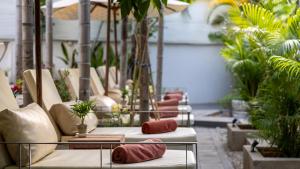 a patio with a bunch of pillows and plants at Reservoir, Yoga & Wellness Retreat in Siem Reap