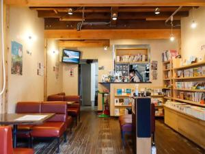 豊岡市にあるPrivate guest house with veranda without bath and shower - Vacation STAY 47236vの椅子とテーブルと本棚のあるレストラン