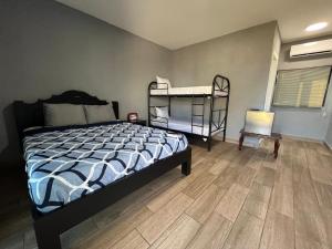 Un dormitorio con dos literas y suelo de madera. en Rancho Agua Fria, en Jucuarán
