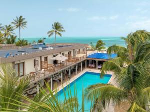 an aerial view of a resort with a swimming pool and the ocean at Blackstone Beach Resort in Uroa