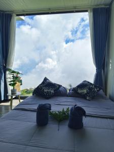 a bed in a room with a large window at ชาร์จแบต ภูทับเบิก in Ban Muang Baeng