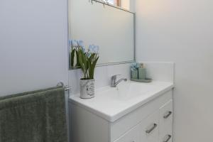 a bathroom with a white sink and a mirror at B1 Airport Haven - Free Parking & Modern Serenity in Perth