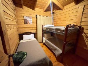 une chambre avec deux lits superposés dans une cabine dans l'établissement Parque Nacional Volcán Poás Cabaña Abby, à Bajos Tigre