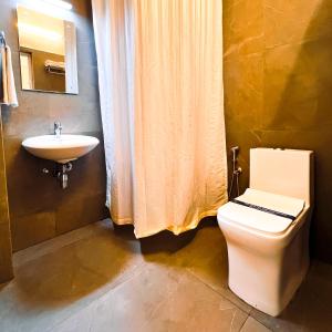 a bathroom with a toilet and a sink at Royal Residency in Kakkanad +45 photos