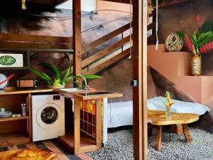a room with a bunk bed and a washing machine at Suite au milieu des arbres in Punaauia