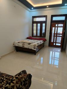 a bedroom with two beds in a room with windows at Mahadev Mahakumbh Homestay Inn in Jhūsi