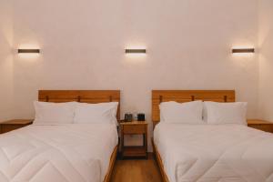 two beds sitting next to each other in a room at Hotel Boutique Casa Yága in Querétaro