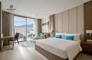 芽庄Moonlight Bay Panorama Condotel Ocean View的一间带大床的卧室和一间客厅