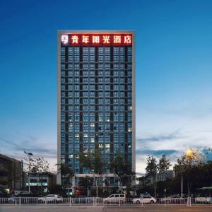a tall building with a sign on top of it at Youth Sunshine Hotel in Xiang'an