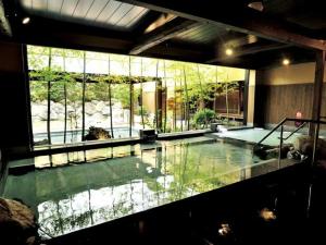 ein großes Schwimmbad in einem Gebäude mit einem großen Fenster in der Unterkunft White Hotel Tsuruhashi in Osaka