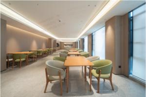 a row of tables and chairs in a room at JI Shanghai International Tourism Liufeng Highway Hotel in Shanghai