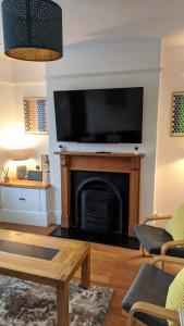 Una sala de estar con chimenea y un televisor de pantalla plana. en Victoria House, en Exeter