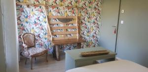 a room with a chair and a table and a wall at les Box chambre d'hôtes in Figeac +17 photos