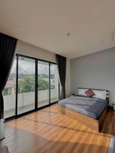 a bedroom with a bed and a large window at Home Anh Thy in Ấp Tân Hà