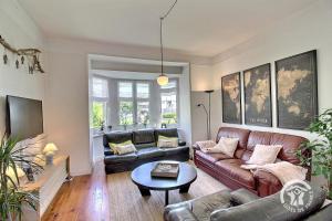 a living room with a leather couch and a table at La villa de la lieue de greve in Plestin-les-Grèves