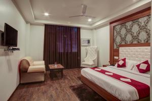 a hotel room with a bed and a chair at Hotel The Royal Krishna in Katra
