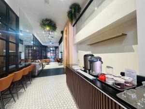 a restaurant with a counter and a bar with chairs at 14 Sathorn Hotel No-Parking in Bangkok