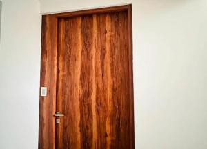 eine Holztür in einem Raum mit einer weißen Wand in der Unterkunft Belond Dep in Mexiko-Stadt